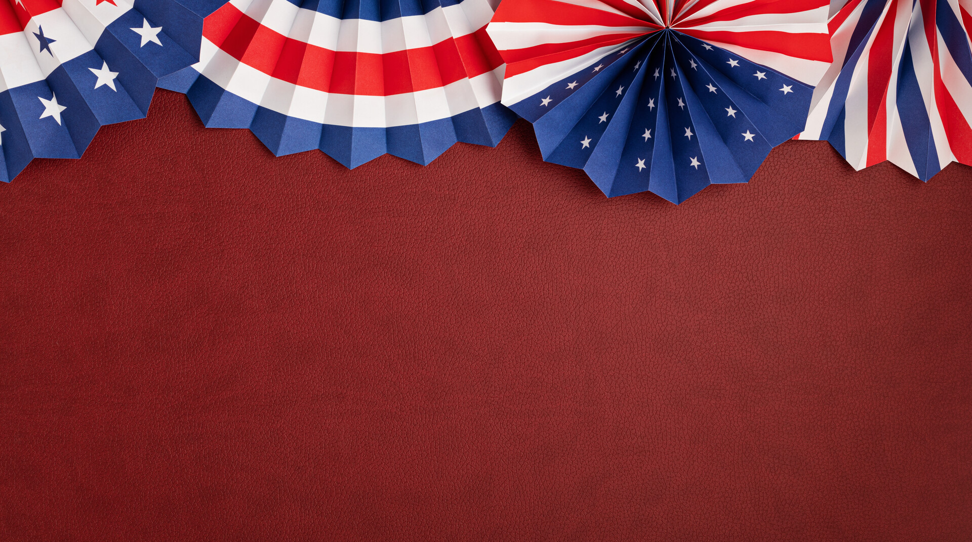 U.S.A themed paper fan decorations on a dark red background