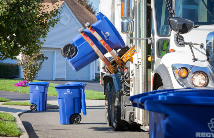 A recycling truck picking up recycling bins.