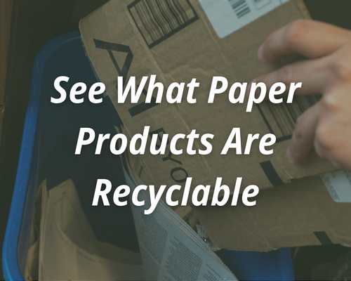 A cardboard box being placed in a small, office recycling bin that has a newspaper in it. The text reads, "See what paper products are recyclable."