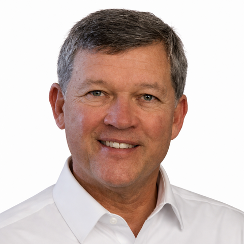 Bill Garvey wears a white button down shirt and smiles.