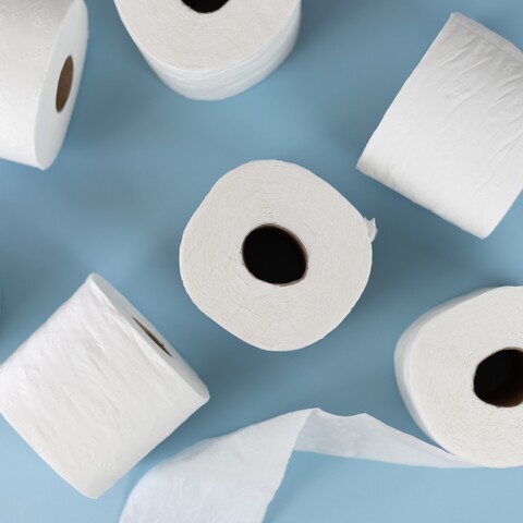 Rolls of white toilet paper on a blue surface